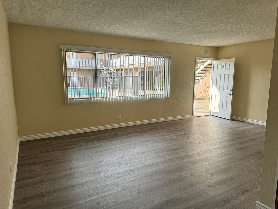 Large living room with new paint, vinyl plank floors and larger size baseboards.