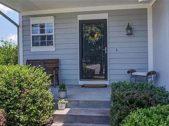 Inviting front porch with storm door.  Enjoy the landscape.