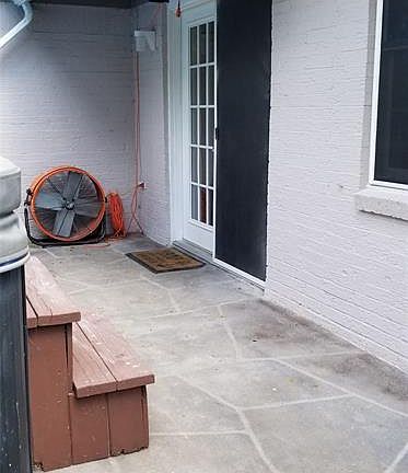 Scored concrete patio overlooks spacious backyard.