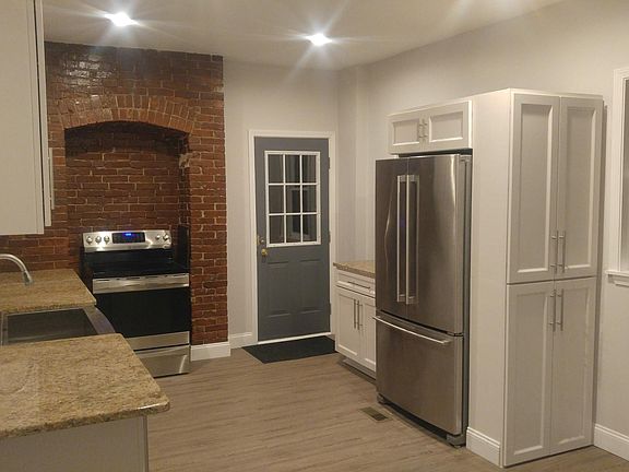 Caramel granite and white lacquer cabinets