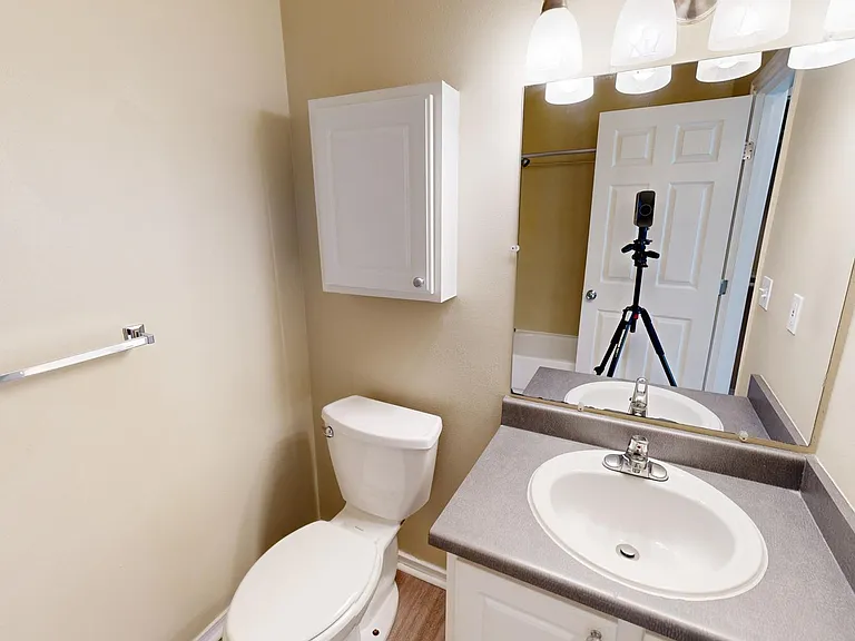 Apartment bathroom with wood-style flooring.