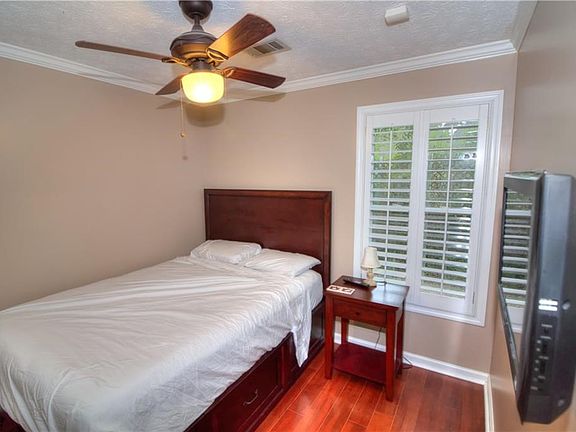 Bedroom Two has hardwood floors, a large custom closet, and a private bath. Both bedrooms have plantation shutters and the depicted furniture and televisions will remain in the unit.