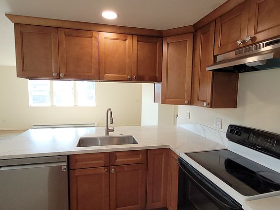 kitchen includes: quartz countertops, undermount sink, disposal, dishwasher, oven, refrigerator