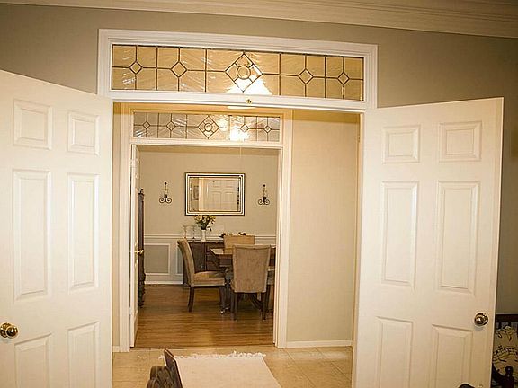 The entries into the study / formal living and the formal dining room are highlighted by transoms above the double doors.