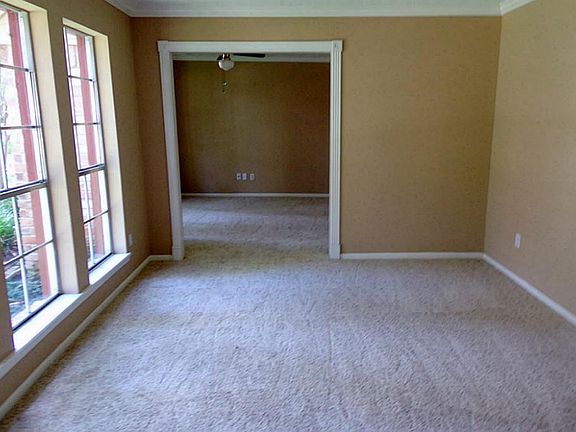 Adjoining formal living and dining with crown molding, fresh paint and carpet.
