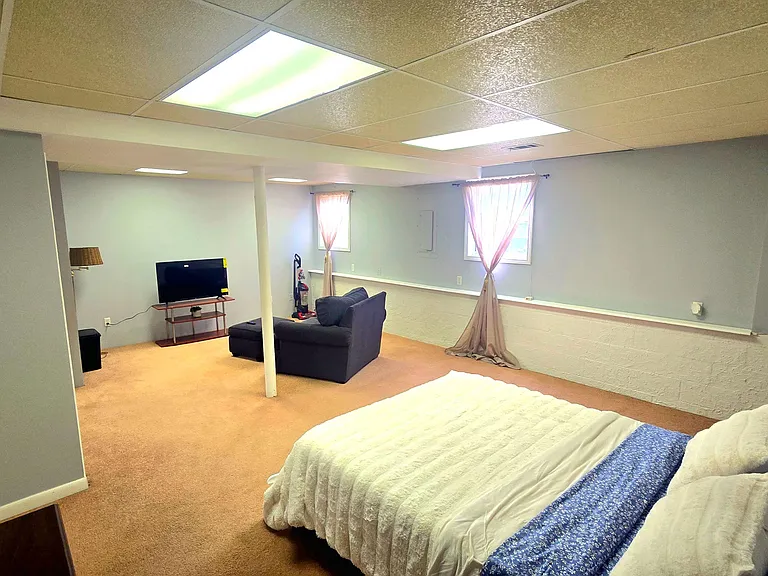 Spacious bedroom suite with a sitting area, room for a full/queen bed, and windows for natural light and ventilation.