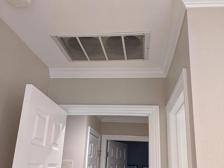 Detail of crown molding, door trim and attic fan.