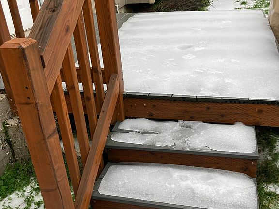 Stairs to entry during ice storm. Normally, these are resilient decking material leading to porch/patio. Separate fenced/private space in this location near entry. For Amazon packages, you can leave the front gate unlocked and the delivery can be placed b