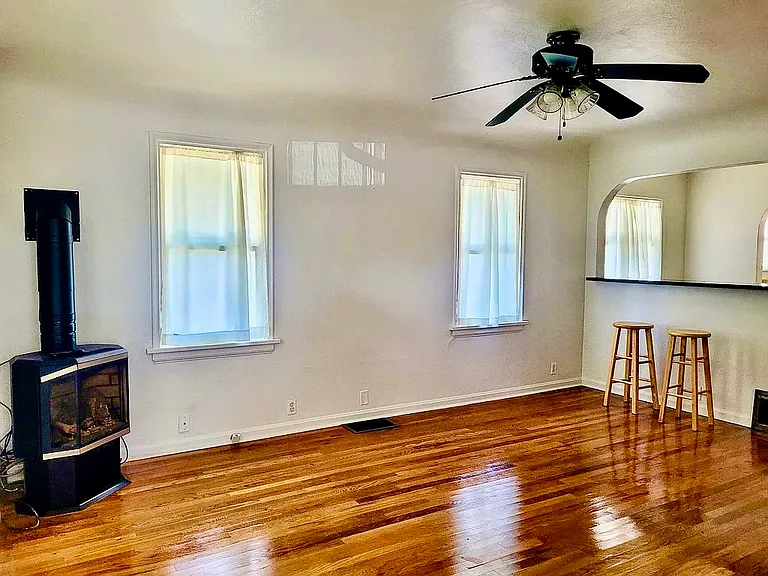 Original hardwood floors throughout. Gas fireplace. Notice bar/pass-through arch into dining area.