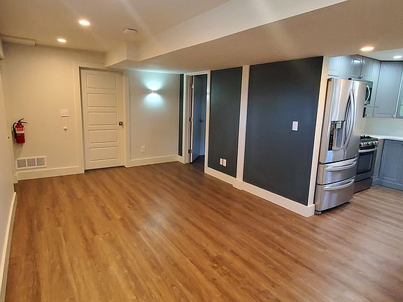 Living room. Entrance door is in left corner. Two bedrooms on both sides of the wall light.