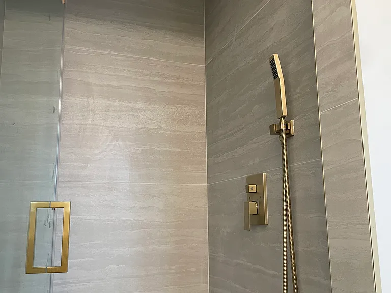 Bathroom2 - custom-designed vanities, Delta gold hardware, large-format tile, and modern rainfall showers