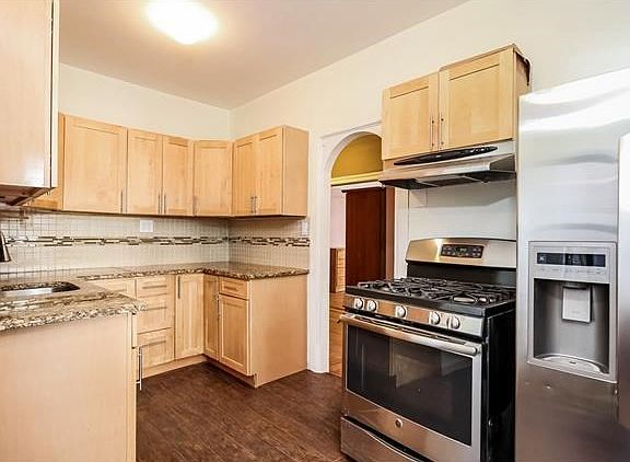 Beyond the two walk-in closets is a classic archway entrance to the totally renovated kitchen