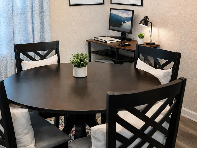 Dedicated dining area with a round table for four, pendant lighting, and easy access to a small work desk nook.