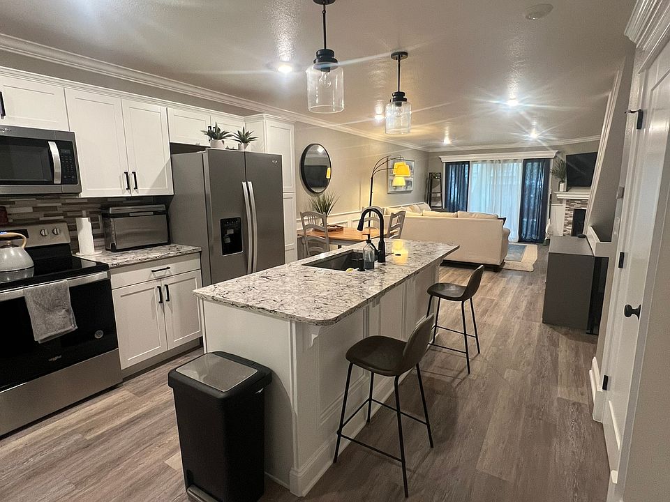 Modern open-concept kitchen featuring granite countertops, stainless steel appliances, a large center island.