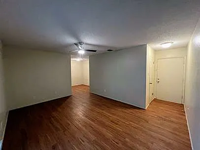 Living room facing dining area in back; apartment entrance and closet/storage on right