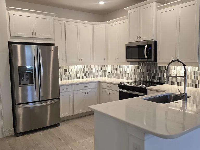 Designer Kitchen featuring upgraded stainless steel appliances and lower cabinets featuring premium pull-out drawers.