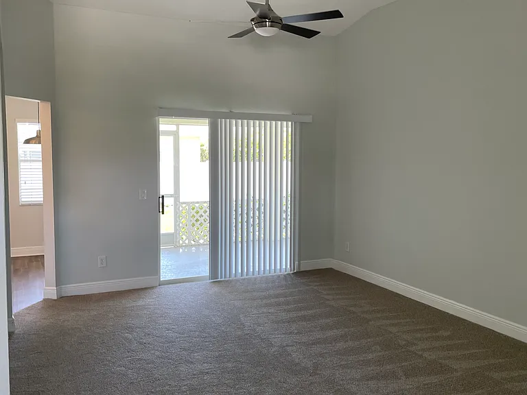 Living room w/vaulted ceiling and sliding glass doors to porch.