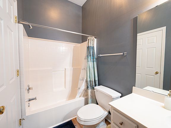 Stackable washer/dryer is located in the closet of this bathroom