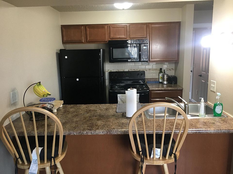 Kitchen has snack bar, nice appliances, cabinets and tile backsplash.