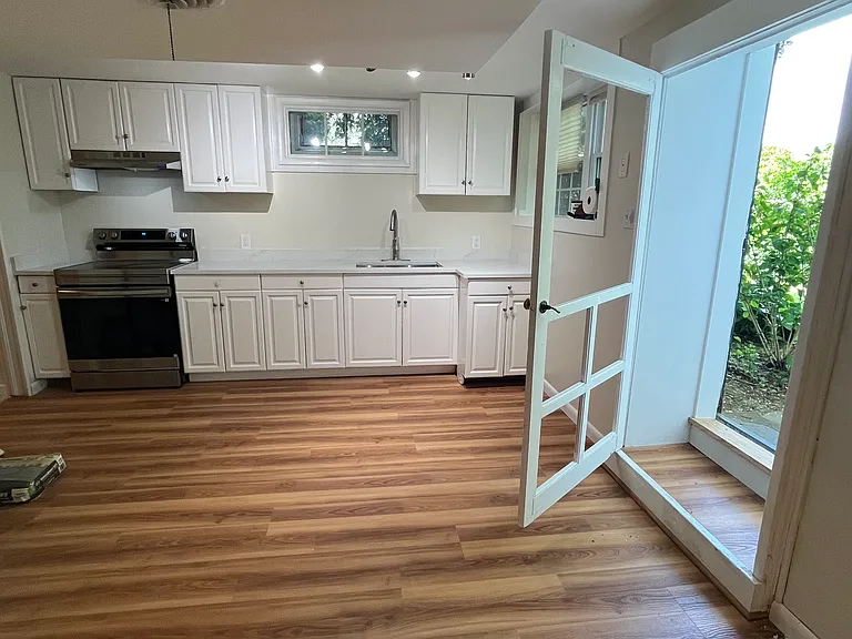 living / dining view towards kitchen and entryway .