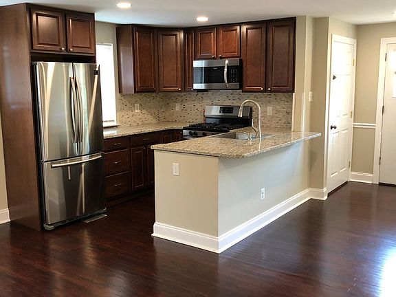 Open concept kitchen with dining room to the left of the fridge.