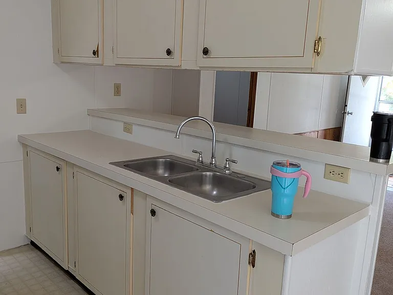 Kitchen view from dining room, tall counter behind sink,
new kitchen faucet installed