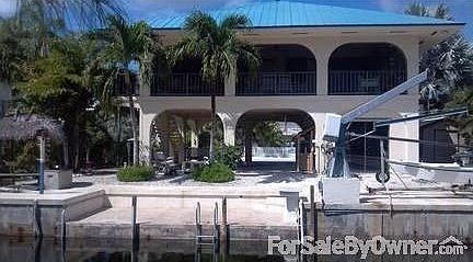 View from canal
						:
						Solid-built concrete & stucco home on a deep, clean, & wide canal facing west!