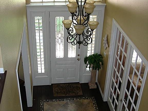 Stunning entry with custom "tile rug" inlay. From the door, to the right is the dining room, and to the left is a study - that is also large enough to be a living room if preferred