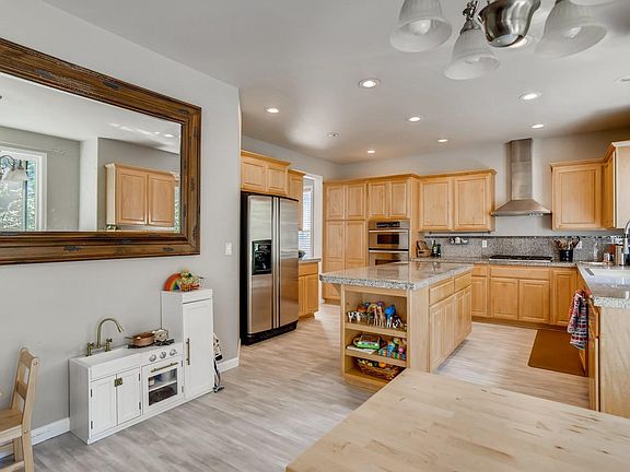 View of the kitchen from the family room.. Stainless top of the line appliances with gas cooking and granite counters
