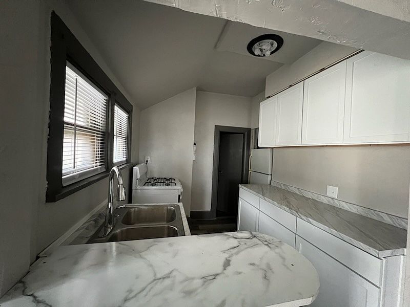 This is the newly remodeled kitchen with brand new cabinets, plenty of storage, refrigerator, and new gas/electric range.