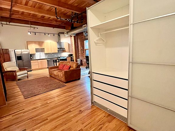 Clothes armoire with living room/kitchen beyond.