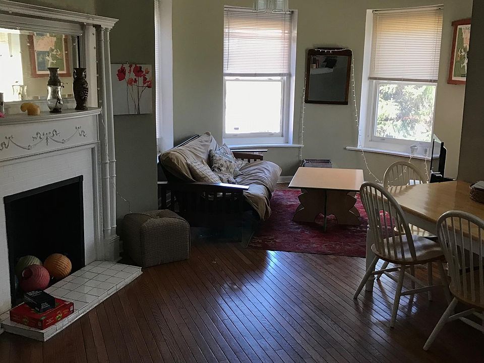 Large living room with unique round turret - large windows with great views of bustling streetscape