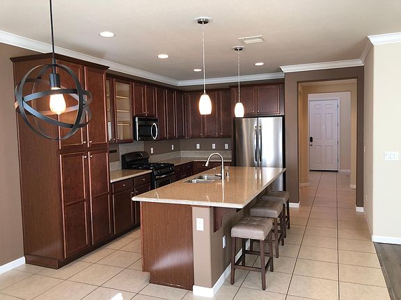 Unstaged kitchen and breakfast bar with included stools