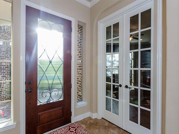 Triple-leaded glass front door with side lights provides a Light-and-Bright entry.