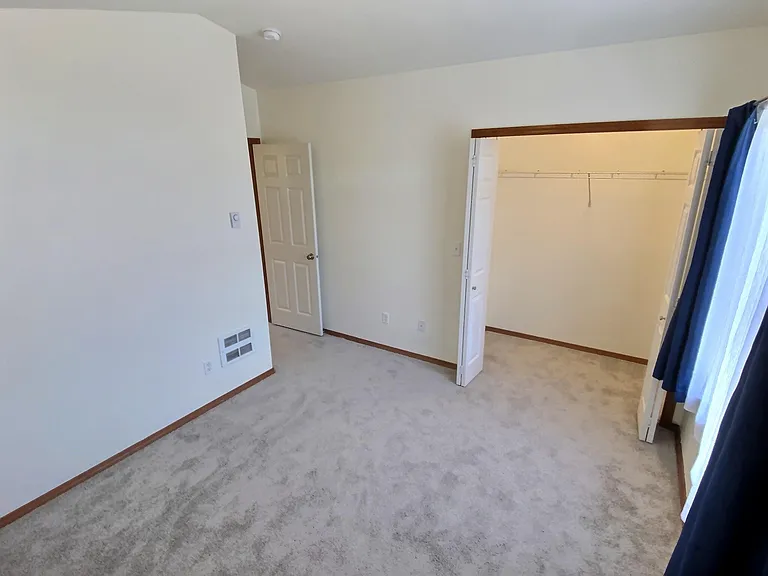 3rd Floor _ Primary bedroom with a vaulted ceiling, large arched window, and abundant natural light.