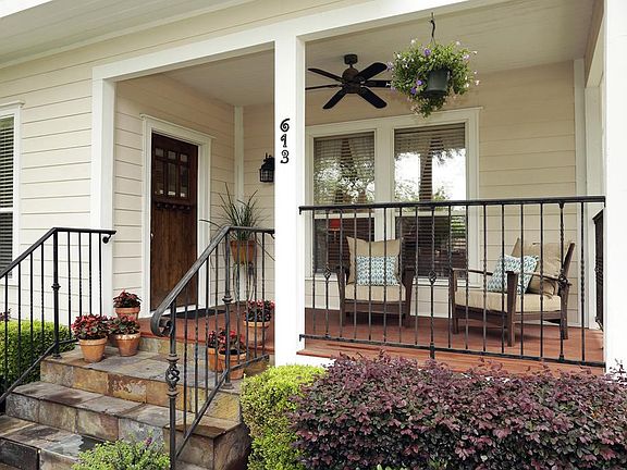 Charming front porch with ceiling fan and ample room for seating.