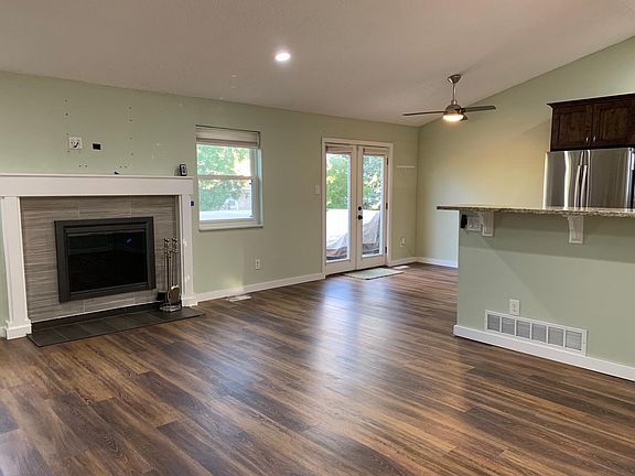 View from front door into living room, beautiful fireplace, looking towards French door access to private deck overlooking back yard.