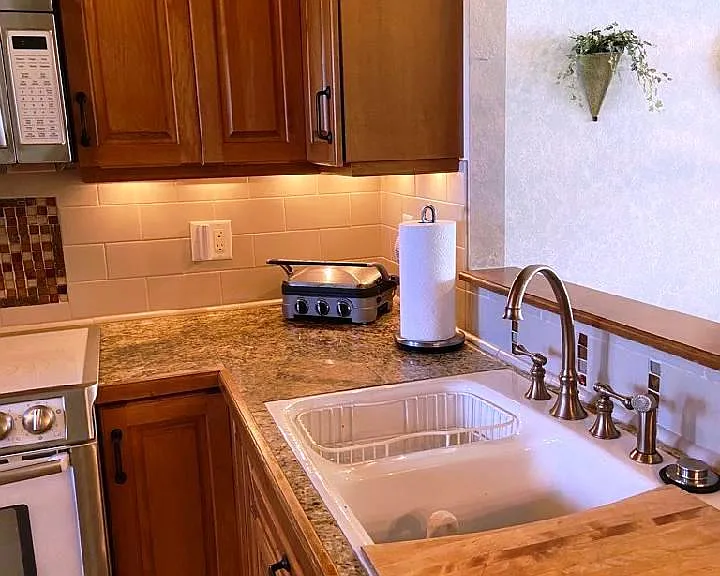 Kohler cast iron sink with small and large basin, racks, cutting board, InSinkErator disposer.
