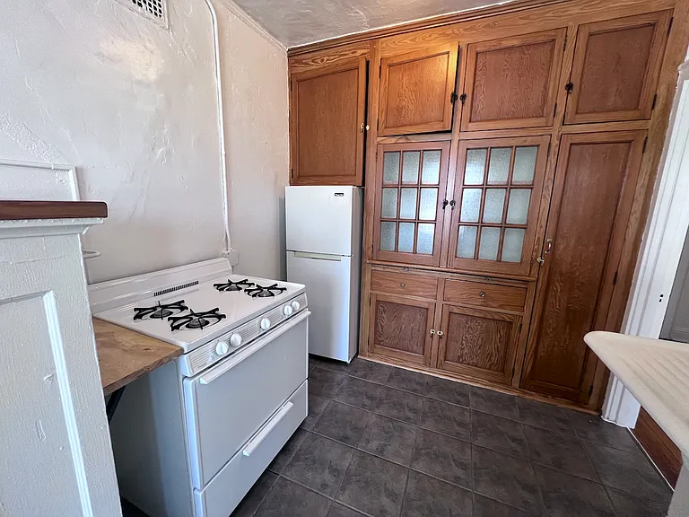 Historic charm meets practical storage in this inviting kitchen, featuring extensive built-in cabinetry, ample pantry space, and a full-size gas range for everyday cooking.