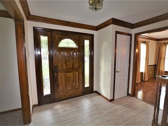 Welcoming entry accented with wood trim, beautiful crown moulding and new tile flooring.
