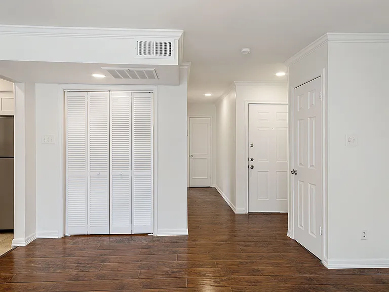 Laundry closet adjacent to the kitchen and hallway leading to the bathroom and bedroom.