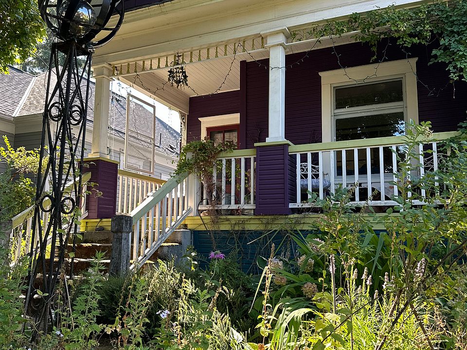 Street facing porch with sculpture near steps.