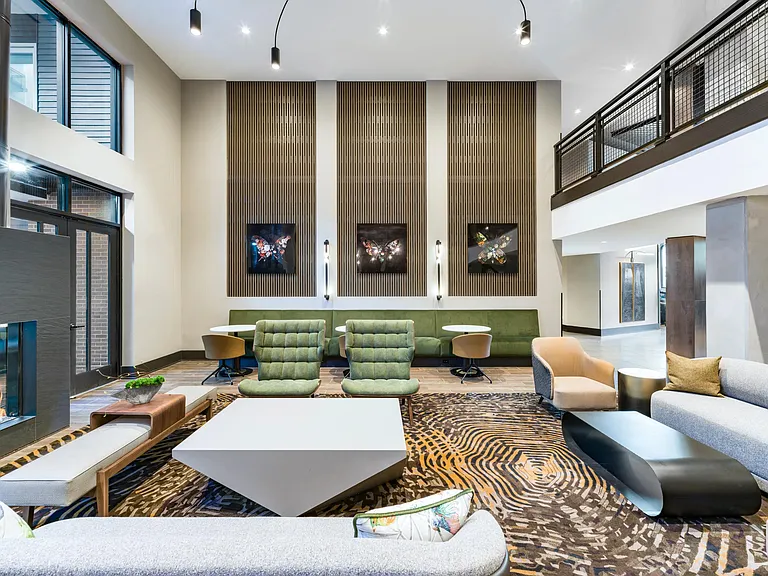 Multi-level resident lounge with layered seating, curated art, and warm finishes designed for gathering, conversation, and everyday connection.