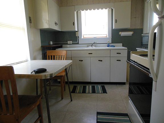Kitchen: range, refrigerator, microwave, large storage cupboard for groceries in addition to those in picture