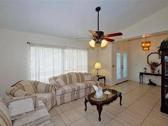 Double door front entry and foyer area flows into formal living room