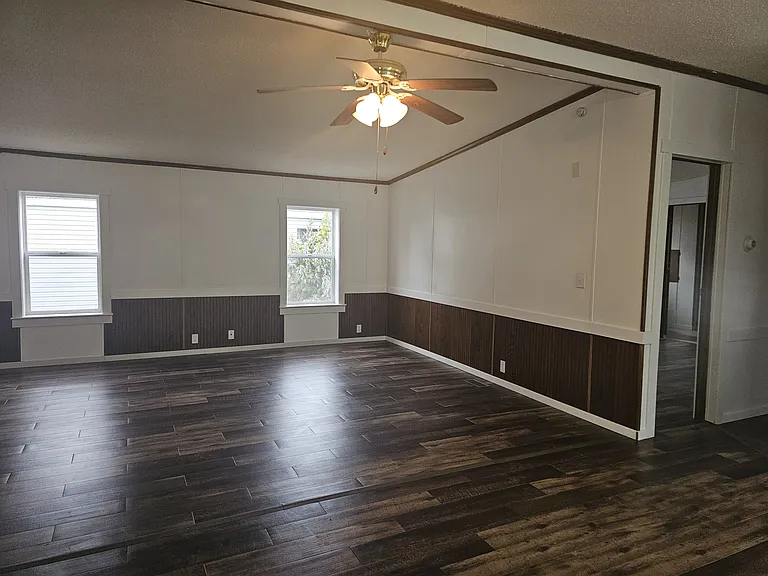 Large living room/family room with ceiling fan. Brand new vinyl plank flooring throughout, brand new vinyl windows, brand new trim, freshly painted.