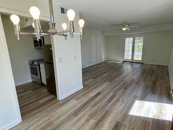 View from Dining area with new brushed nickel chandelier into great room and kitchen entry
