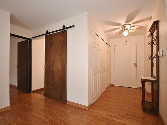 The foyer is spacious and has a wall of closet space. Notice the barn door to the bathroom - - this unit has some great updates!