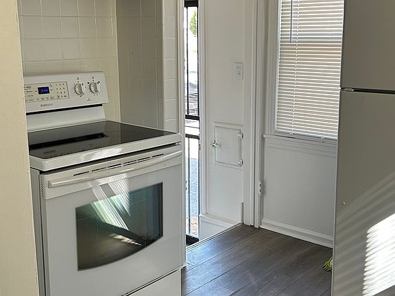 Bright kitchen with updated flooring, full-size appliances, and convenient rear access