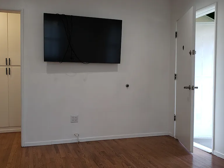Front wall with front door on the right and entrance to hall on the left.
